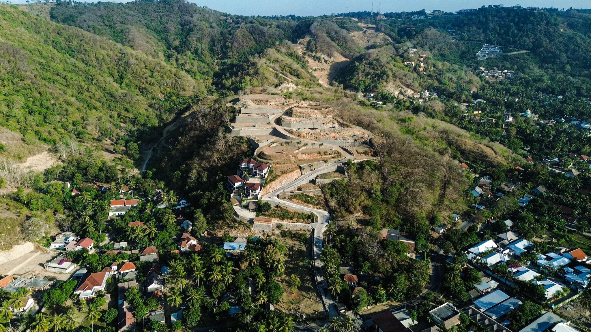 Aerial view of the hillside context around the Citra site, with surrounding landscape and village.